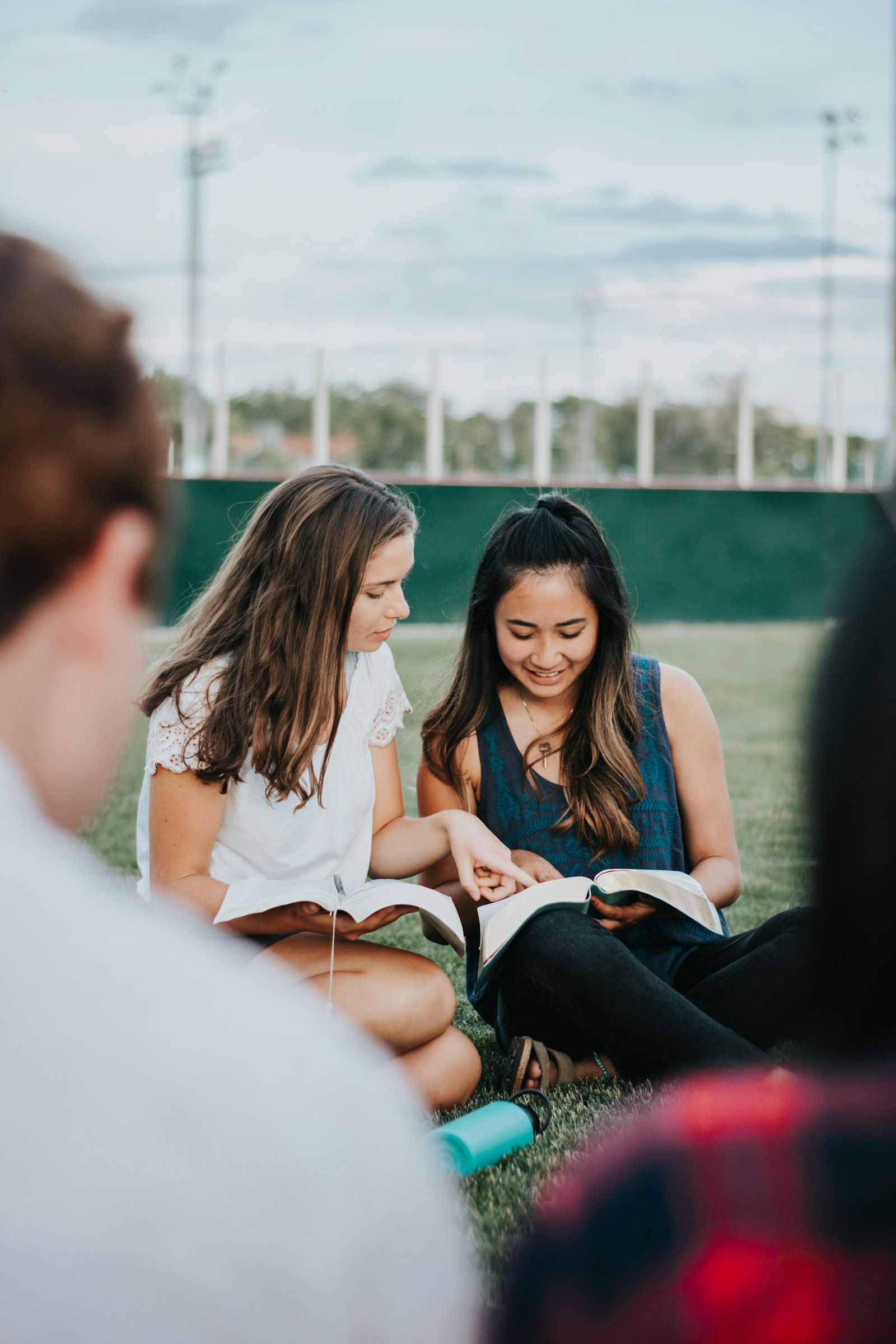 A group of people sitting together looking at an open book.